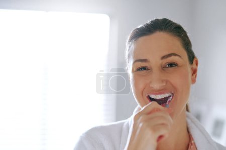 Photo for Because fresh breath never goes out of style. a woman brushing her teeth in the bathroom at home - Royalty Free Image