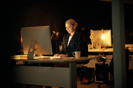 Photo for Ill be done in a bit. a mature businesswoman working late at the office - Royalty Free Image