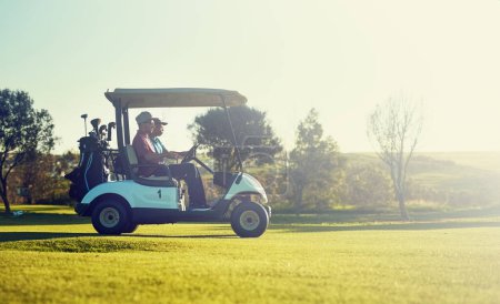 Téléchargez les photos : Gone clubbin. deux golfeurs en chariot sur un terrain de golf - en image libre de droit