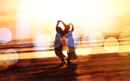 Foto de Nadie es demasiado viejo para los cuentos de hadas. dos mujeres jóvenes pasando el día en la playa al atardecer - Imagen libre de derechos