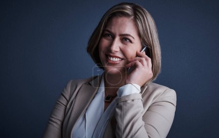 Photo for Communication is the key to success. Studio shot of an attractive young corporate businesswoman making a call against a dark background - Royalty Free Image