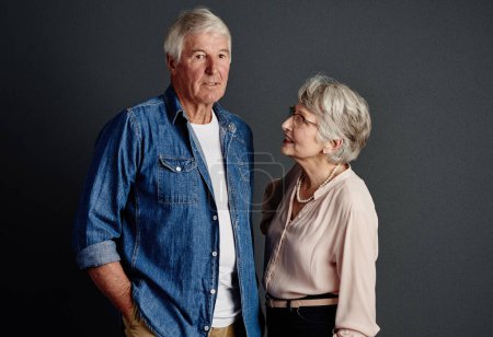 Téléchargez les photos : Je le joue cool. Portrait studio d'un couple de personnes âgées affectueux posant sur un fond gris - en image libre de droit