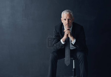 Photo for Hes the best performing CEO in business. Studio portrait of a mature businessman against a dark background - Royalty Free Image