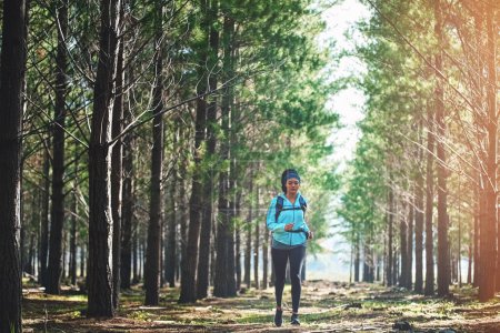 Photo for I can. I will. End of story. Full length shot of an athletic young woman out for a jog in the woods - Royalty Free Image