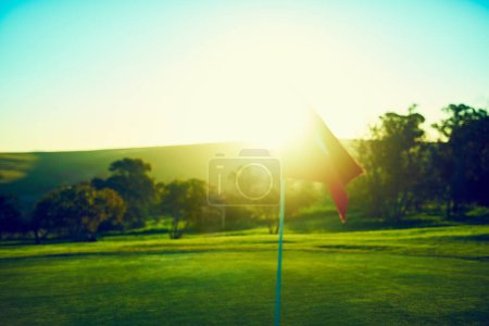 Foto de Y así comienza la temporada de golf. una bandera en un campo de golf - Imagen libre de derechos