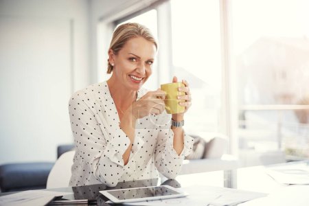 Téléchargez les photos : Elle adore commencer sa journée de travail avec du café. une femme d'affaires mature travaillant depuis son bureau à domicile - en image libre de droit