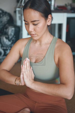 Foto de El yoga es una de las mejores soluciones para aliviar el estrés. una joven meditando mientras practica yoga en casa - Imagen libre de derechos