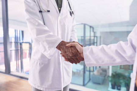 Foto de Serás un gran activo para esta compañía. dos doctores irreconocibles dándose la mano mientras están en el hospital - Imagen libre de derechos