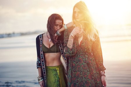 Foto de Libérate de la ropa aburrida. dos mujeres jóvenes pasando el día en la playa al atardecer - Imagen libre de derechos