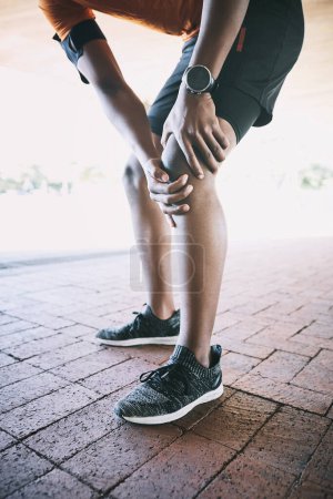 Photo for Fight through the bad days to get to the good. a man experiencing joint pain while working out against an urban background - Royalty Free Image