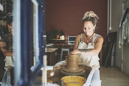 Téléchargez les photos : L'artisanat est une forme de découverte de soi. une jeune femme travaillant avec de l'argile dans un atelier de poterie - en image libre de droit