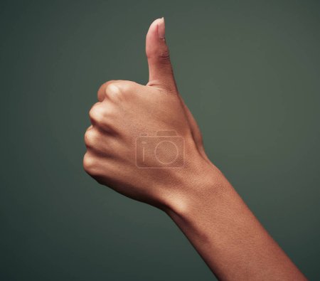 Photo for Thumbs up, hand gesture with emoji and agreement, person with approval and feedback isolated on green background. Yes, like and thank you, mockup space with OK sign and support closeup in studio. - Royalty Free Image