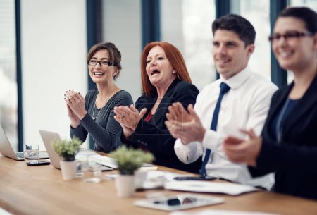 Photo for Theyre loving the ideas theyve heard in this presentation. a group of businesspeople applauding while sitting in a boardroom - Royalty Free Image