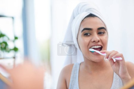 Foto de Pasta de dientes, mujer y cepillo de dientes para la limpieza de dientes, salud dental o ducha matutina en el baño. Chica, cara en espejo y lavando la boca con cepillo de dientes, higiene y sonrisa para la salud y el bienestar. - Imagen libre de derechos