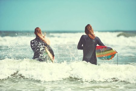 Photo for Couples who surf together stay together. a young couple surfing at the beach - Royalty Free Image