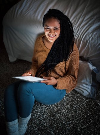Photo for One on one time with the web. a relaxed young woman using a digital tablet during the evening at home - Royalty Free Image