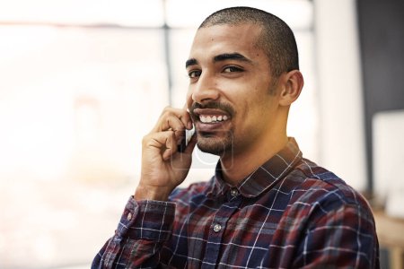 Foto de Sabe cómo manejar los negocios con confianza. un joven empresario hablando por celular en una oficina - Imagen libre de derechos