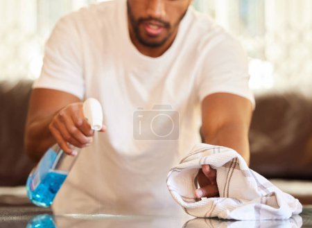 Photo for Man, clean table with spray and cloth, chemical detergent and wipe dirt from furniture. Housekeeping, male cleaner hands with closeup and hygiene, cleaning house with bottle and disinfecting surface. - Royalty Free Image