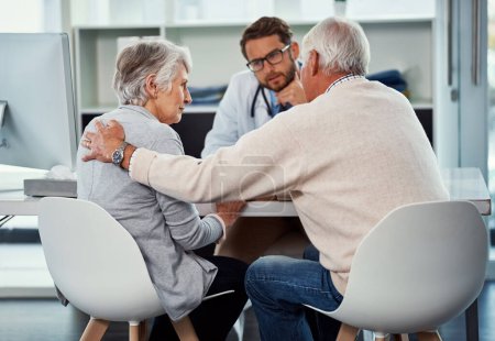 Photo for Well face this challenge together. a senior man consoling his wife during a consultation with a doctor in a clinic - Royalty Free Image
