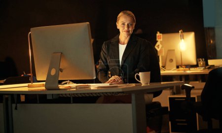 Foto de Ningún plazo es imposible de cumplir. una mujer de negocios madura que trabaja hasta tarde en la oficina - Imagen libre de derechos