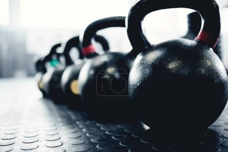 Photo for Fitness, weights and kettlebell on floor of gym for workout, strong and exercise. Metal, iron and performance with sports equipment in training center for weightlifting, wellness and challenge. - Royalty Free Image