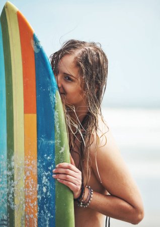Foto de Hora de coger algunas olas. una joven atractiva parada en una playa con una tabla de surf - Imagen libre de derechos