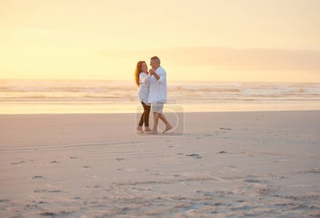 Téléchargez les photos : Rompre leur retraite. un couple mature dansant sur la plage - en image libre de droit