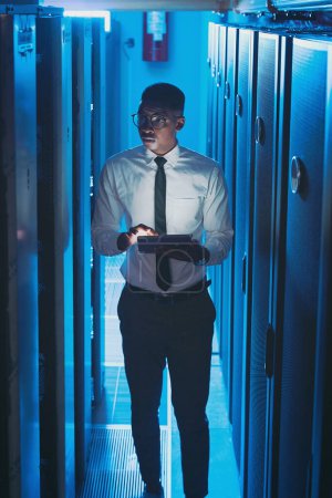 Photo for Technology is a part of my life. a young IT specialist standing alone in the server room and using a digital tablet - Royalty Free Image