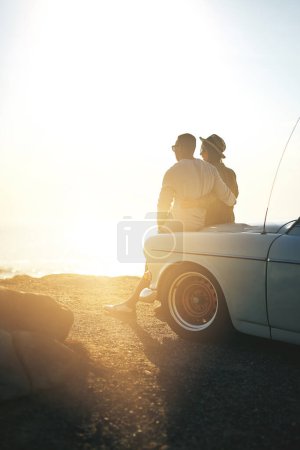 Téléchargez les photos : Bébé, ce n'est rien comparé à ta beauté. un jeune couple faisant une halte à la plage lors d'un road trip - en image libre de droit