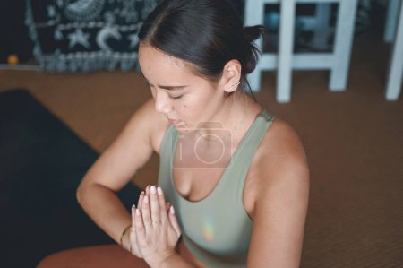 Foto de El yoga nos enseña a ser más amables con nosotros mismos. una joven meditando mientras practica yoga en casa - Imagen libre de derechos