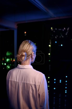 Photo for Ill have to do some work to fix this quickly. Rearview shot of a young woman working in a server room - Royalty Free Image