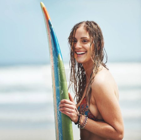 Foto de Es hora de encontrar olas. una joven atractiva parada en una playa con una tabla de surf - Imagen libre de derechos