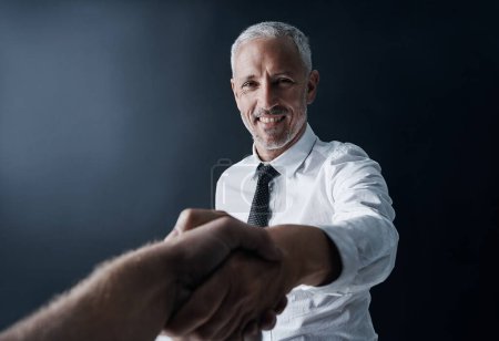 Photo for Welcome to the team. Cropped portrait of a mature businessman shaking your hand in agreement - Royalty Free Image