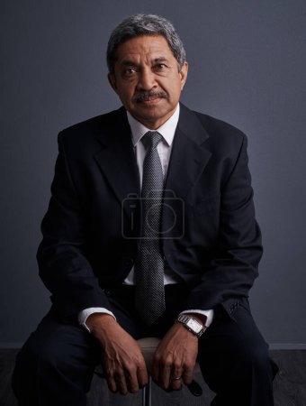 Foto de Es el hombre de negocios del año. Estudio de un hombre de negocios maduro posando sobre un fondo oscuro - Imagen libre de derechos