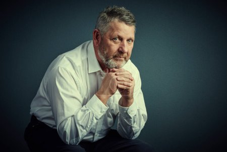 Photo for Business comes naturally to me. Studio portrait of a handsome mature businessman looking thoughtful while sitting down against a dark background - Royalty Free Image
