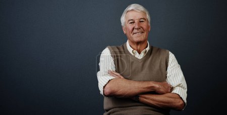 Photo for Hes a confident individual. Studio portrait of a handsome mature man posing with his arms crossed against a dark background - Royalty Free Image