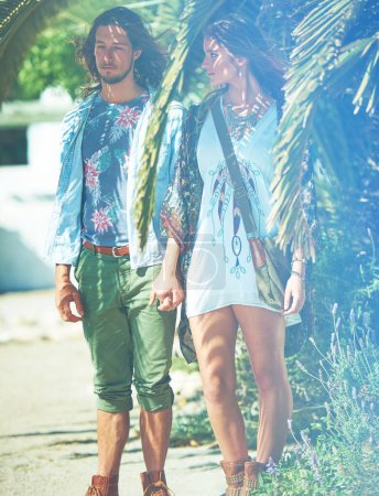 Foto de En el amor en la naturaleza. una joven pareja de pie de la mano afuera bajo una palmera - Imagen libre de derechos