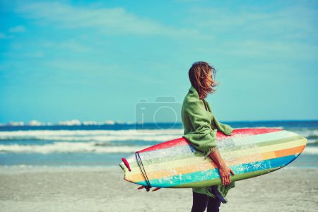 Foto de A donde voy, mi tabla de surf va. un joven surfista paseando por la playa con su tabla de surf - Imagen libre de derechos