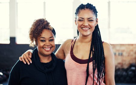 Photo for Amped to start exercising. Portrait of two cheerful young women having a conversation while looking into the camera before a workout session in a gym - Royalty Free Image