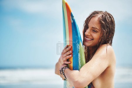Téléchargez les photos : Board, j'allais arracher ces vagues. une jolie jeune femme debout sur une plage embrassant sa planche de surf - en image libre de droit