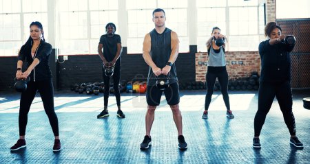 Photo for Staying strong and fit together. a fitness group using kettle-bells in their session at the gym - Royalty Free Image