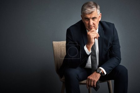 Photo for Success is his area of expertise. Studio shot of a mature businessman posing against a grey background - Royalty Free Image