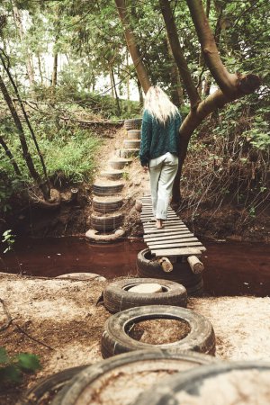 Foto de La emoción se construye con cada paso a través de la naturaleza. una mujer cruzando una pasarela mientras explora la naturaleza - Imagen libre de derechos
