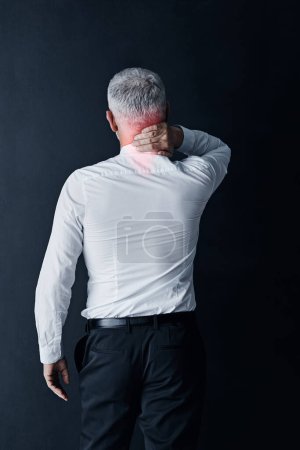 Photo for He carries a lot of tension in his neck. Rearview shot of a mature businessman holding his neck in pain - Royalty Free Image