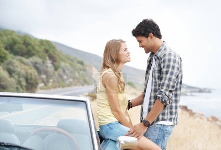 Téléchargez les photos : Perdu dans l'instant présent. Un jeune couple partageant un moment romantique sur une colline après avoir fait un tour panoramique - en image libre de droit