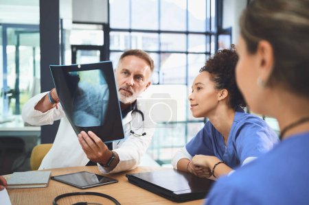 Téléchargez les photos : Évaluons la situation de plus près. une équipe de médecins analysant les rayons X lors d'une réunion dans un hôpital - en image libre de droit