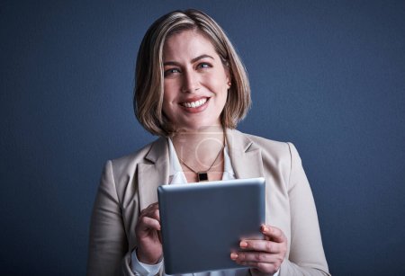 Photo for It makes business easier. Studio portrait of an attractive young corporate businesswoman using a tablet against a dark background - Royalty Free Image