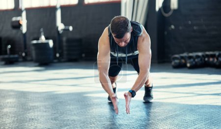 Photo for Exercise to better your body. a young man doing push ups in a gym - Royalty Free Image