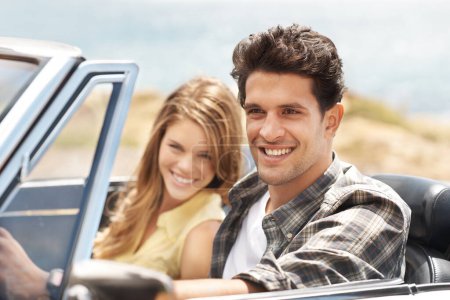 Téléchargez les photos : Route vers nulle part. Un jeune homme séduisant conduisant une voiture de sport avec sa petite amie à côté de lui - en image libre de droit