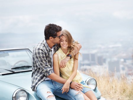 Photo for Youre my sweetheart. Cute young couple sitting on the hood of their convertible while on a break from their roadtrip - Royalty Free Image